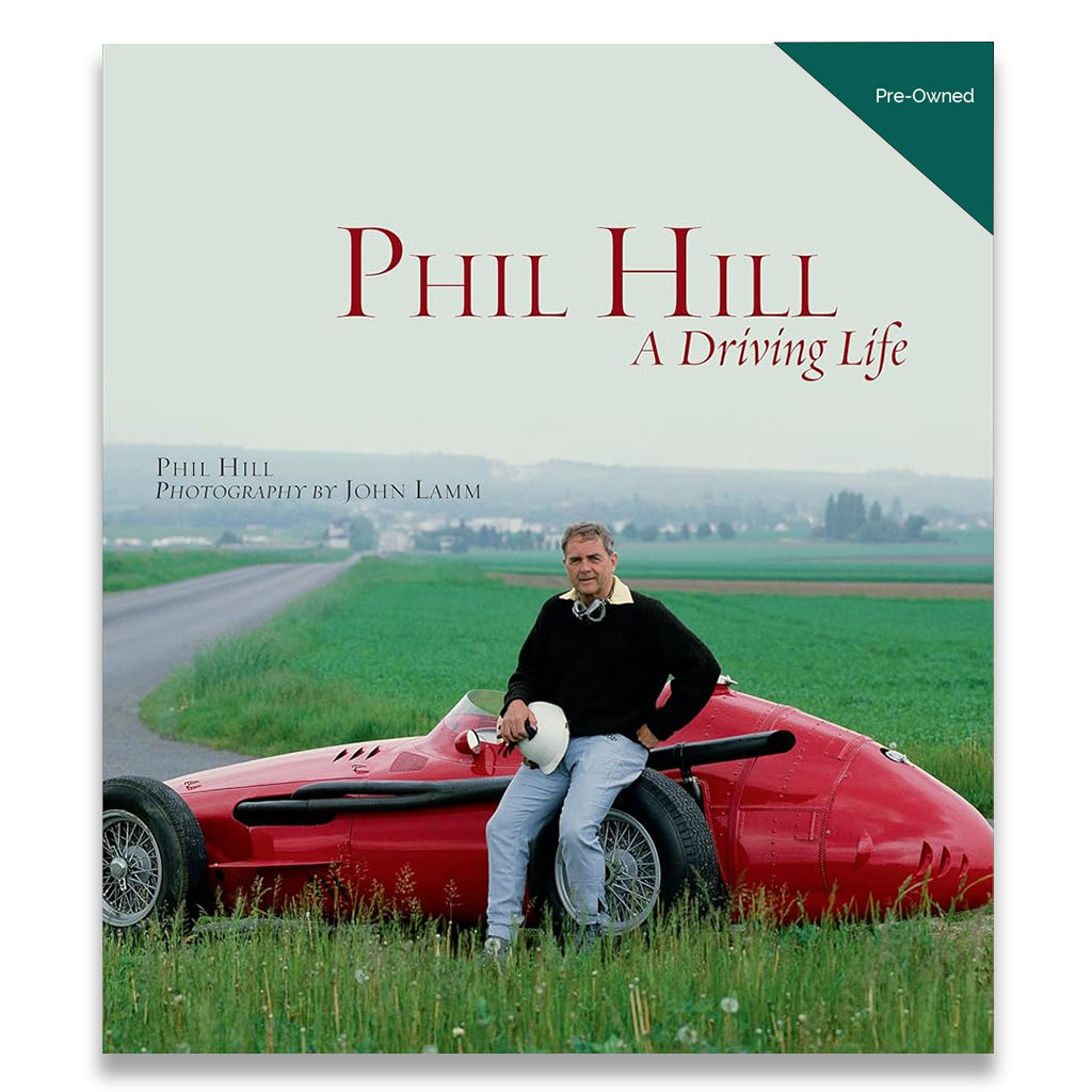 Book cover of 'Phil Hill: A Driving Life' with a person sitting on a red car in a green landscape.